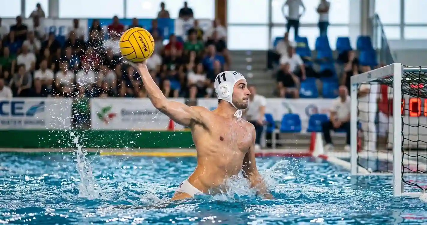 Pallanuotista in azione di tiro durante un derby di cartello di Serie A1 con pubblico sulle tribune del palazzetto